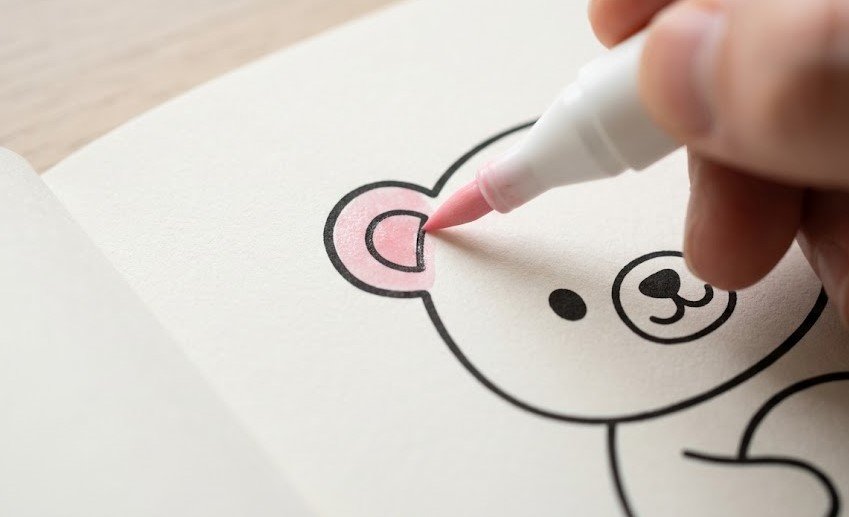 Close-up de uma ilustração do livro Bobbie Good original edição Day to Night (Dia para a Noite) sendo colorida com caneta azul.